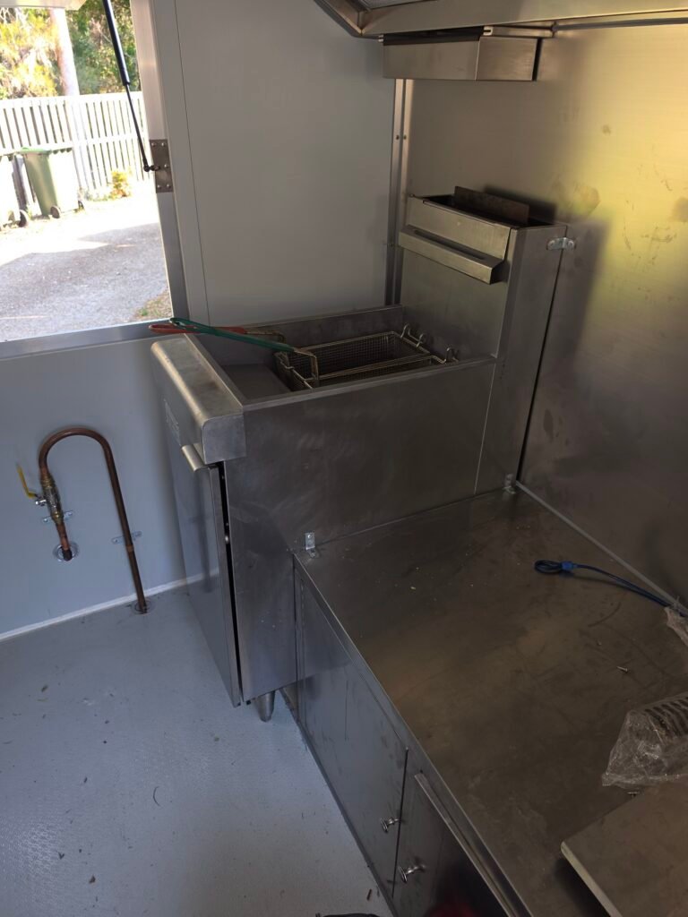 Interior of a food trailer kitchen showing copper gas line connection and fryer basket, gas fitted by LTC Gas